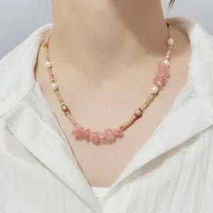 Close-up of a pink natural stone and pearl beaded necklace on model
