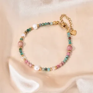 Detailed view of a beaded bracelet featuring natural stones, pearls, and a heart charm.