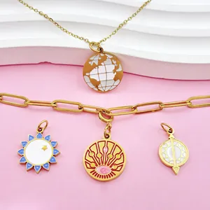 Close-up of gold-plated tarot sun and globe pendants with colorful enamel details
