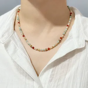 Detail shot of a vibrant natural stone beaded necklace worn on a model's neck area.
