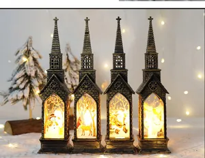 Quattro lanterne natalizie a forma di chiesa in bronzo con calde scene a LED all'interno.