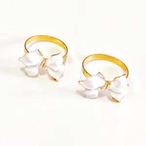 Dettaglio ravvicinato di portatovaglioli vintage con fiocco bianco e perle eleganti