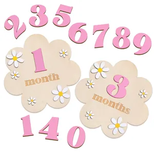 Bloemvormige houten babymijlpaalkaarten met roze cijfers voor pasgeboren fotografie.