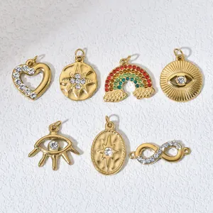 Close-up of various gold-plated stainless steel charms with sparkling colorful crystals.