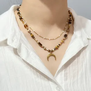 Detail of vintage double-layer necklace with natural tiger eye beads and crescent moon