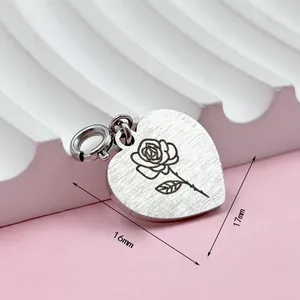Vue détaillée d'un pendentif coeur en acier inoxydable avec gravure de rose et dimensions