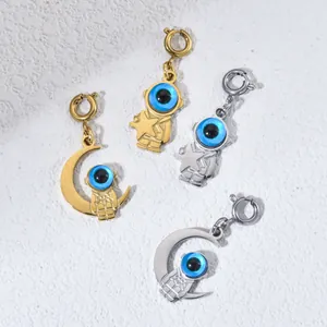 Detailansicht von Astronauten-Anhängern in Gold und Silber mit blauen Augenperlen aus Edelstahl.