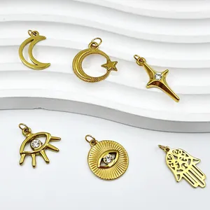 Gedetailleerd overzicht van vergulde evil eye, ster en maan bedeltjes met kristallen