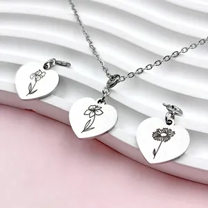 Vue détaillée de pendentifs cœur en acier inoxydable avec motifs de fleurs de naissance