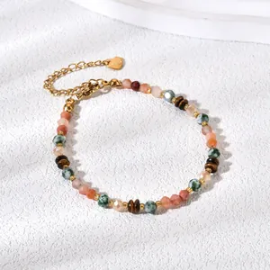 Detailed view of colorful natural stone beaded bracelet with gold chain and heart charm