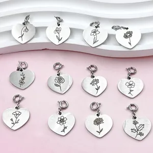 Vue détaillée de 12 pendentifs en acier inoxydable en forme de cœur avec gravures de fleurs.