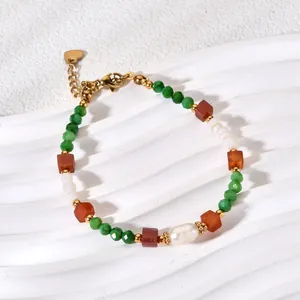 Macro view of handmade natural stone bracelet with green/red beads and pearl accents