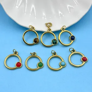 Détail de pendentifs circulaires en acier inoxydable doré avec diverses pierres