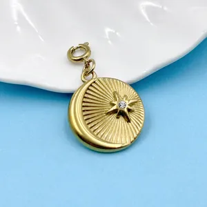 Détail macro du pendentif céleste en acier doré avec motif soleil, lune et étoile.