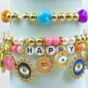 Detailaufnahme von Evil-Eye-Anhängern und HAPPY-Perlen an einem bunten Perlenarmband