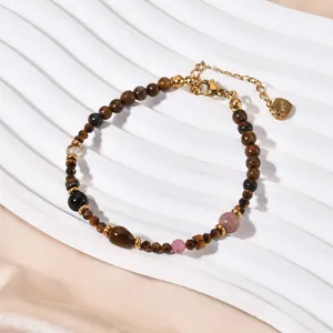 Detail of tiger eye and agate beaded bracelet with stainless steel heart tag