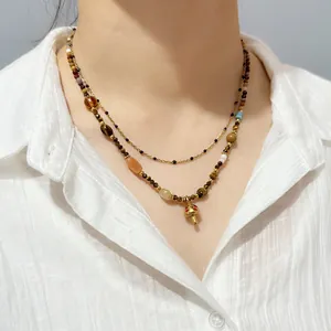 Close-up of vintage tiger eye stone beaded necklace with a cute gold mushroom pendant