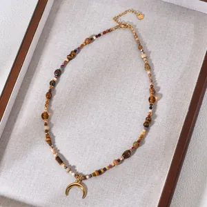 Close-up of tiger eye and agate beaded necklace with gold crescent moon pendant