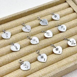 Vue détaillée de douze pendentifs en acier inoxydable avec gravures de fleurs de naissance