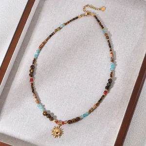 Detailed view of tiger eye and agate beaded necklace featuring a golden sun pendant.