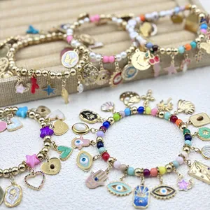 Multi-colored beaded charm bracelets with detailed evil eye and hamsa hand pendants.