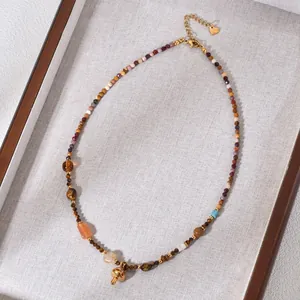 Detailed macro view of vintage beaded necklace with tiger eye stones and golden mushroom pendant