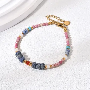 Close-up of colorful natural stone beaded bracelet with gold heart charm and lobster clasp.
