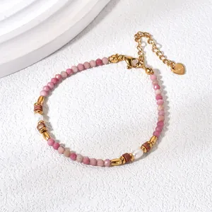 Macro view of natural pink rhodochrosite stone bracelet with gold hardware and pearl