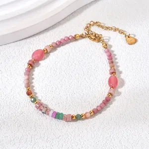 Close-up of a colorful natural stone bracelet with gold beads and rhodochrosite
