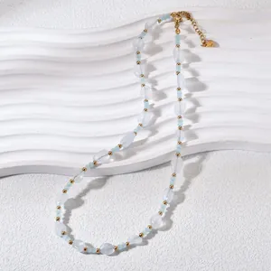 Close-up view of natural light blue crystal stone beads with gold accents necklace