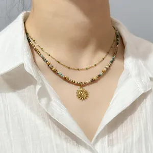 Close-up of Bohemian layered necklace with natural stone beads and sun moon pendant