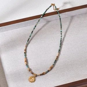 Detailed view of Bohemian beaded necklace with African pine stones and gold sun pendant