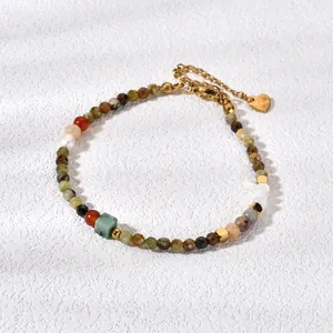 Close-up of candy-colored tourmaline and agate bead bracelet with golden heart charm