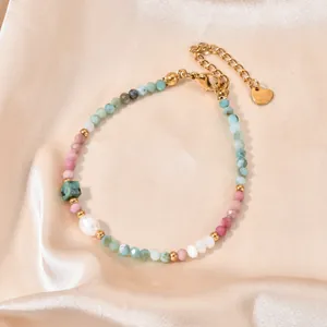 Detailed view of colorful natural stone beads and pearl on a gold-plated bracelet.