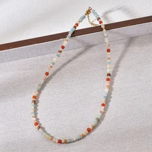 Detailed macro view of colorful natural stone beaded necklace displayed on a grey tray