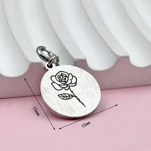 Detailopname van een 15mm roestvrijstalen ronde hanger met een verfijnde roos gravure.