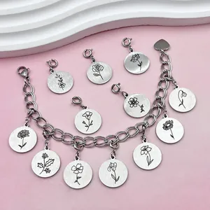 Gedetailleerde weergave van roestvrijstalen geboortebloem bedels aan een schakelarmband