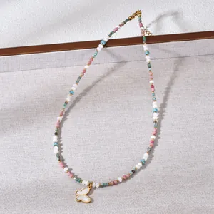 Colorful beaded necklace with a golden butterfly shell inlay pendant, detail view.