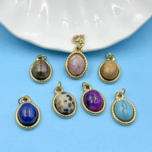 Gros plan de pendentifs ovales en pierre naturelle avec montures en acier doré 18K