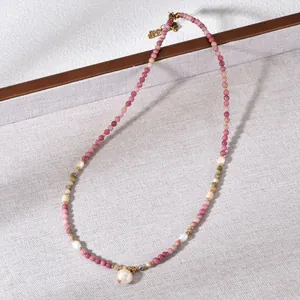 Detailed close-up of pink and white beaded necklace with pearl pendant