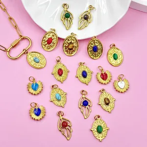 Detailed view of 18K gold plated stainless steel heart, leaf, and oval stone pendants