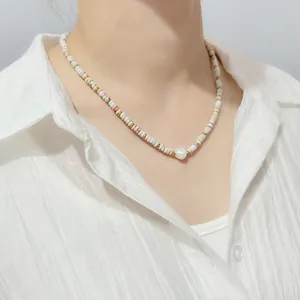 Detail shot of a colorful natural stone beaded necklace with a central freshwater pearl.