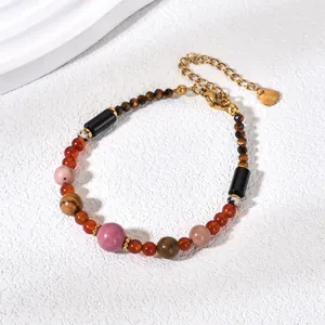 Detail of a handmade natural stone beaded bracelet featuring a gold-toned heart charm.