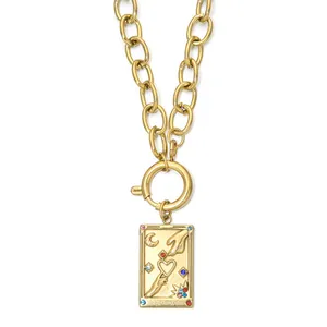 Close-up macro view of gold stainless steel tarot card pendant with moon and sun motifs