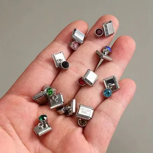 Primo piano di moduli per bracciali charm italiani in acciaio inox con gemme colorate.