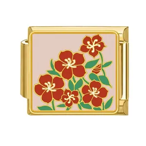 Detailed view of a gold-plated Italian charm with red flower and green leaf pattern