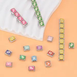 Gros plan sur des charms italiens DIY colorés avec divers symboles des signes du zodiaque.