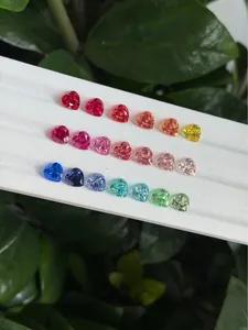Piedras preciosas de colores en forma de corazón creadas en laboratorio en bandeja blanca.