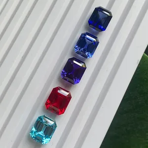Conjunto de gemas de laboratorio talla esmeralda en una bandeja de exhibición blanca.