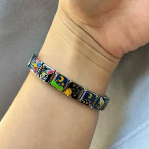 Détail du bracelet italien à breloques modulaires avec motifs émaillés d'espace et de chat